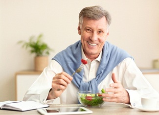 Older man eating salad in Fresno
