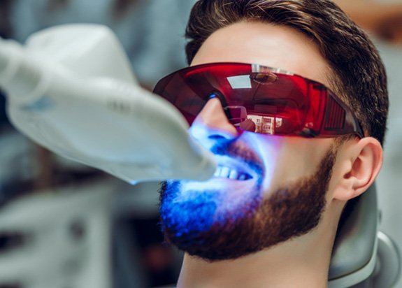 A closeup of a man receiving teeth whitening treatment