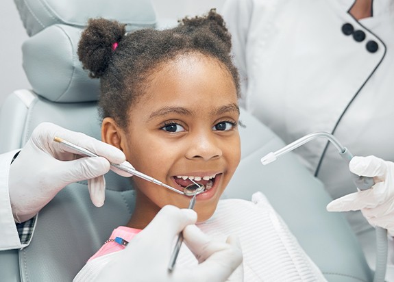 Child receiving dental checkup and teeth cleaning