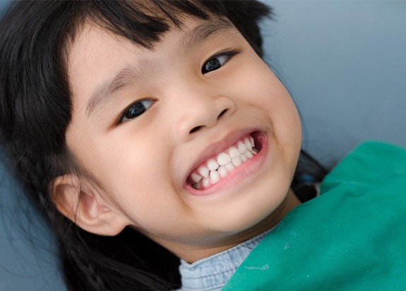 Child smiling after fluoride treatment