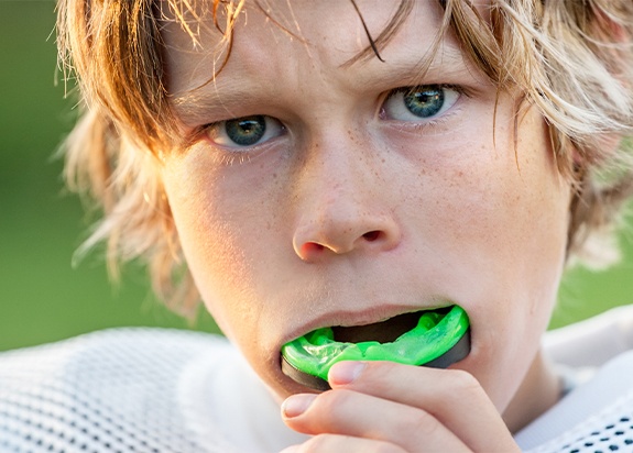 Teen boy placing athletic mouthguard