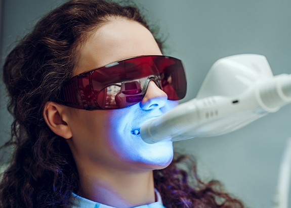 Woman receiving teeth whitening treatment