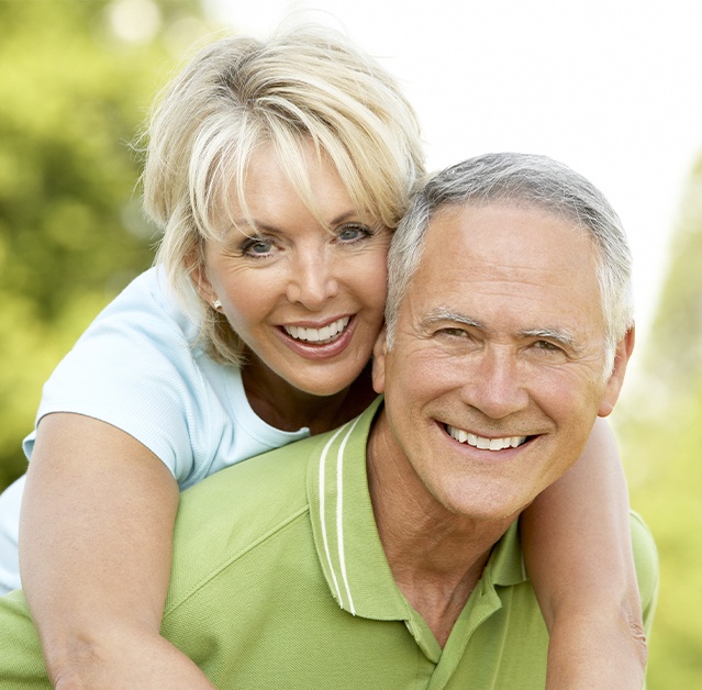 Man and woman with dentures smiling together