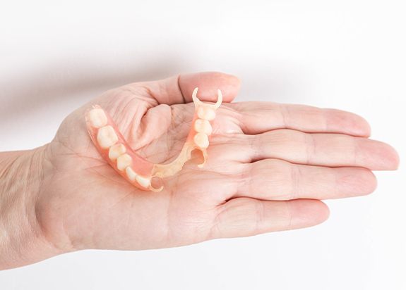 Hand holding a partial denture