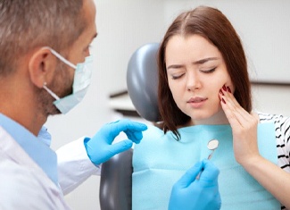 dental patient holding her mouth in pain