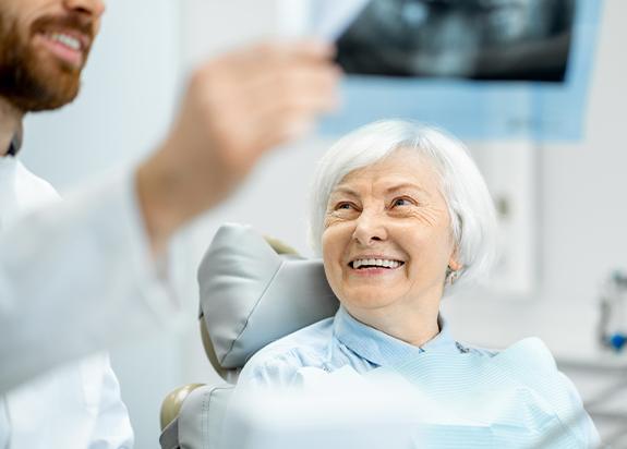 Patient with dental implant retained denture and dentist talking