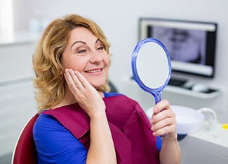 Woman admiring her new dental implants in Fresno 