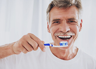 man brushing his teeth