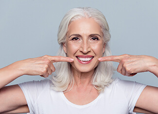 woman pointing to her smile