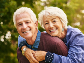 Senior man and woman smiling outside