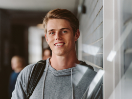 Young man leaning against wall