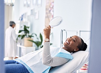 Woman smiling while looking at reflection in mirror