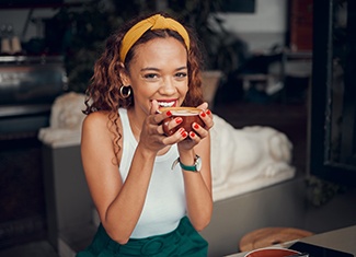 Woman smiling while enjoying cup of coffee