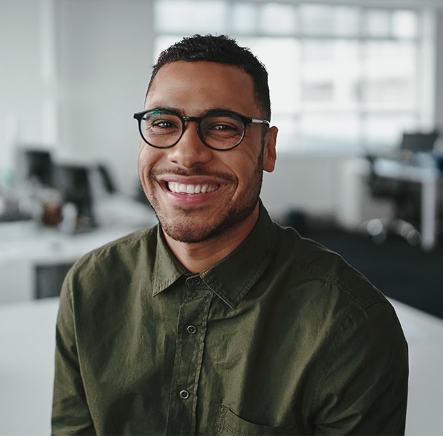 Man with healthy smile after treatment with Invisalign clear braces