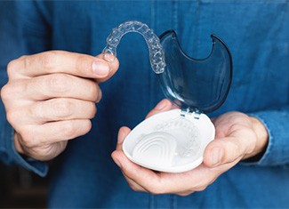 Teen holding clear aligner