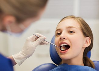 Teen girl smiling during dental exam