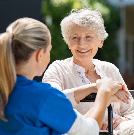 elderly woman smiling with team member in Fresno