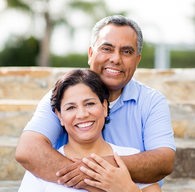 Man and woman sharing healthy smiles after periodontal disease treatment