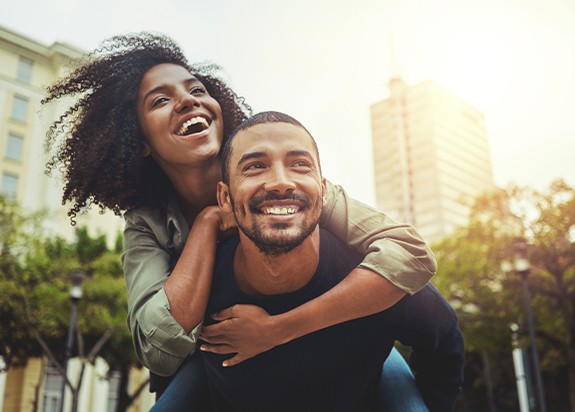 Man and woman with healthy smiles thanks to antibiotic therapy for gum disease