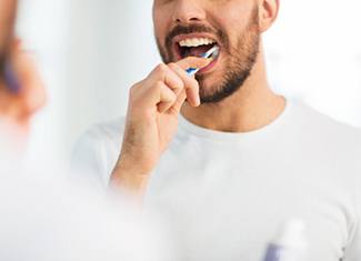 a man brushing his teeth in the morning