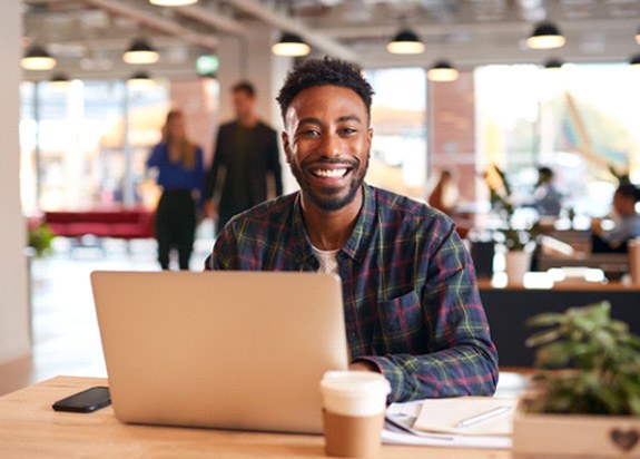 Man smiling while working on computer in office