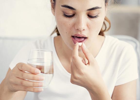 Woman taking an oral conscious dental sedation pill