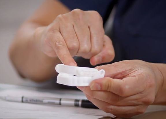 Patient pointing to sleep apnea oral appliance