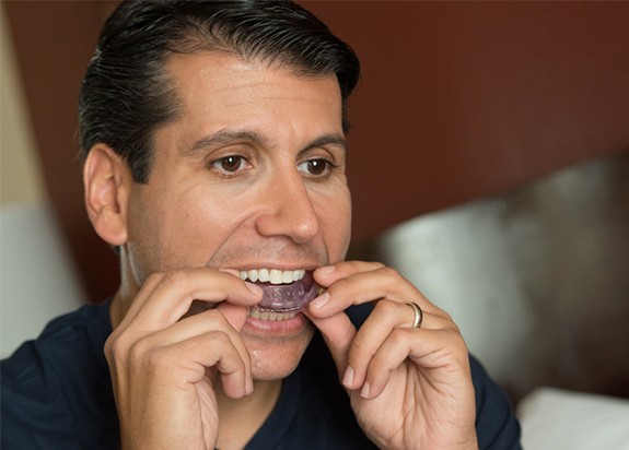 Man placing sleep apnea oral appliance