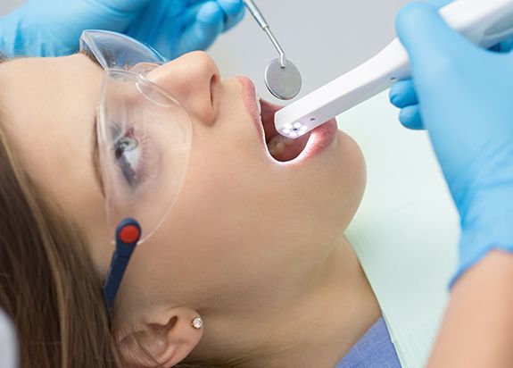 Dentist using intraoral camera to capture images of patient's smile