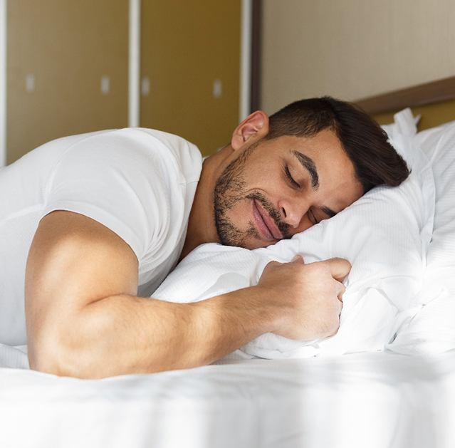 Man sleeping peacefully in bed after Vivos sleep apnea treatment in Fresno, CA