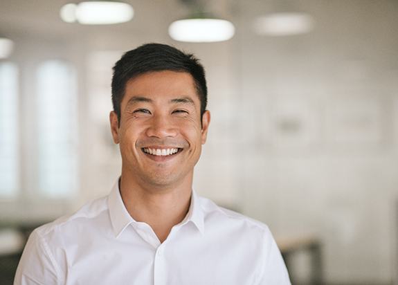 Man in white shirt smiling in office space