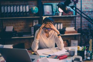 Stressed woman sitting in front of a laptop at home