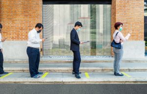 People practicing social distancing while waiting in line