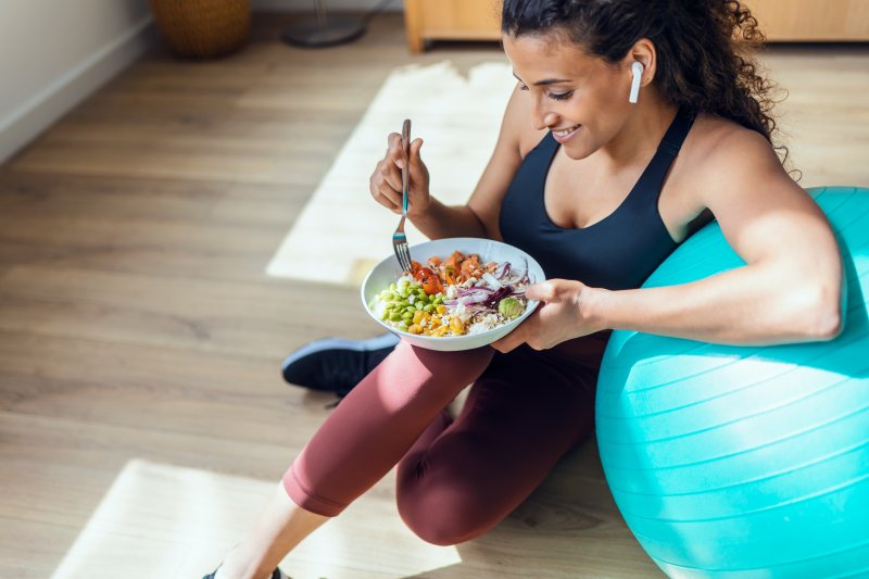 An active woman with dental implants eating healthy