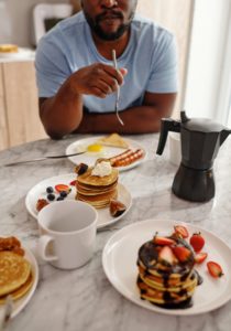 Man sitting at a table eating breakfast