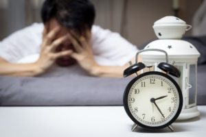 man tired head down by clock