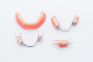 Full and partial dentures on white background